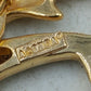 Goldfarbene Brosche mit zwei springenden Delfinen in elegantem maritimem Design