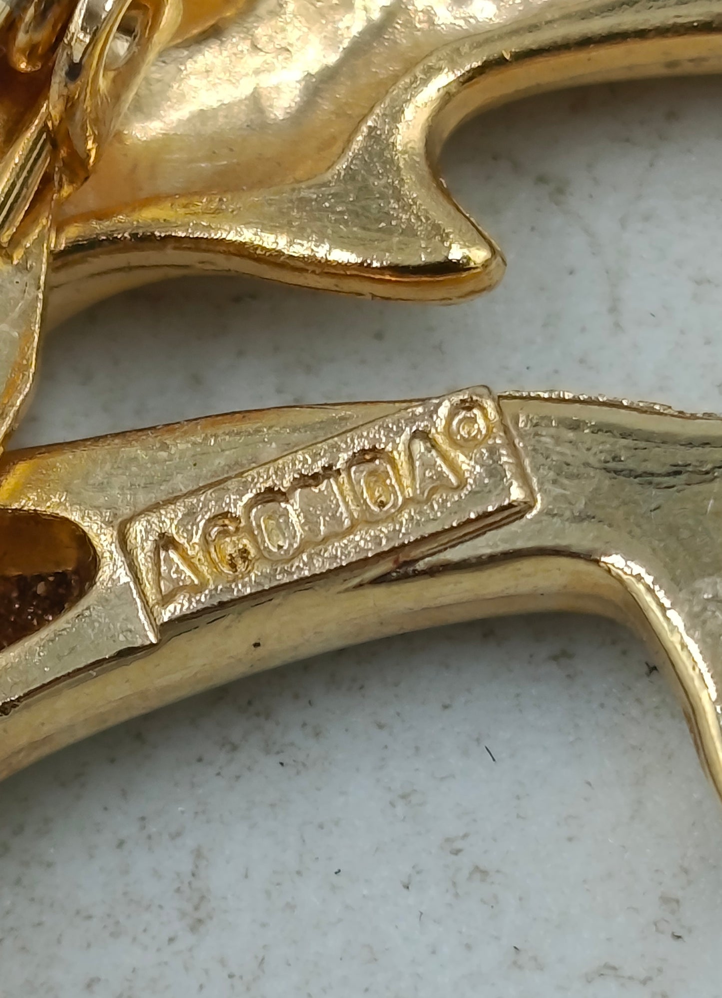 Goldfarbene Brosche mit zwei springenden Delfinen in elegantem maritimem Design