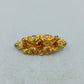Goldfarbene Brosche mit filigranem Ornamentdesign und funkelnden Steinen