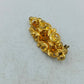 Goldfarbene Brosche mit filigranem Ornamentdesign und funkelnden Steinen
