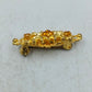 Goldfarbene Brosche mit filigranem Ornamentdesign und funkelnden Steinen