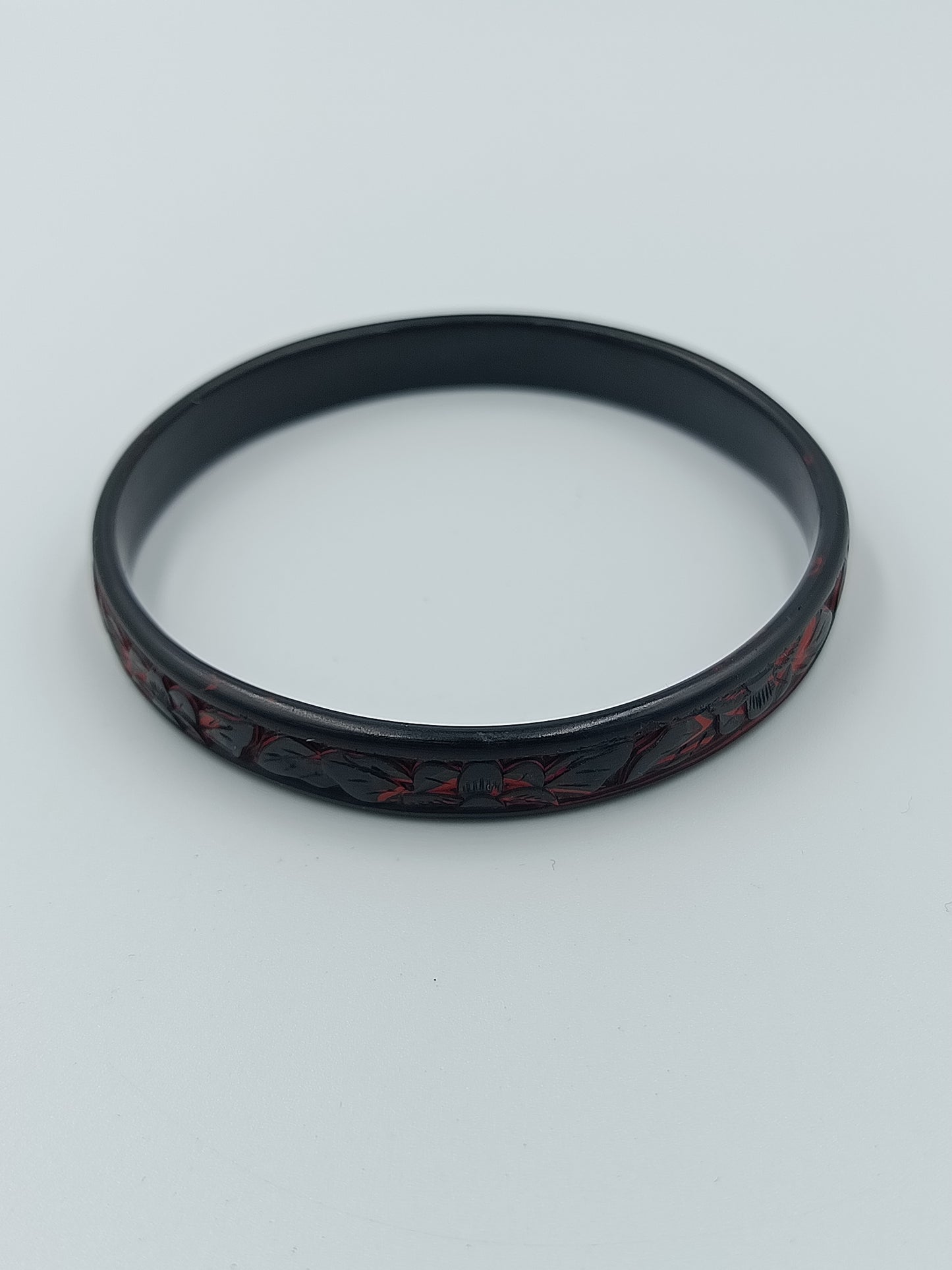 Schmaler Armreif in Schwarz mit rotem floralen Dekormuste