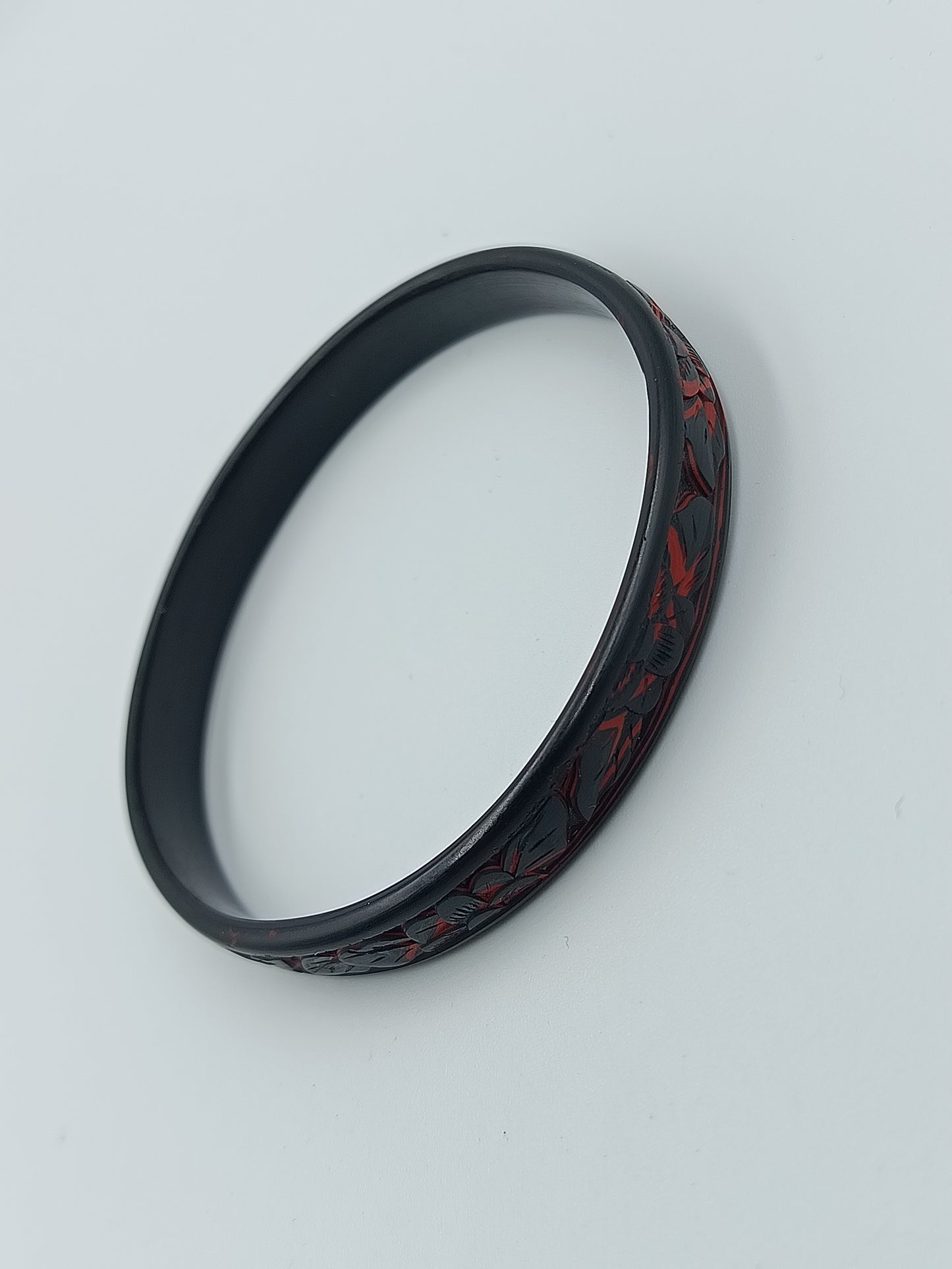 Schmaler Armreif in Schwarz mit rotem floralen Dekormuste