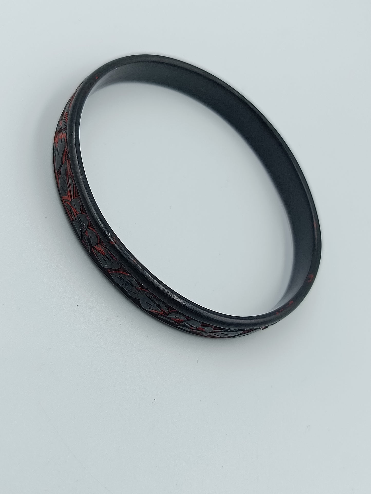 Schmaler Armreif in Schwarz mit rotem floralen Dekormuste