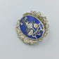 Vintage Anstecknadel mit blauem Emaille Motiv und dekorativem Metallrahmen