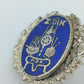 Vintage Anstecknadel mit blauem Emaille Motiv und dekorativem Metallrahmen