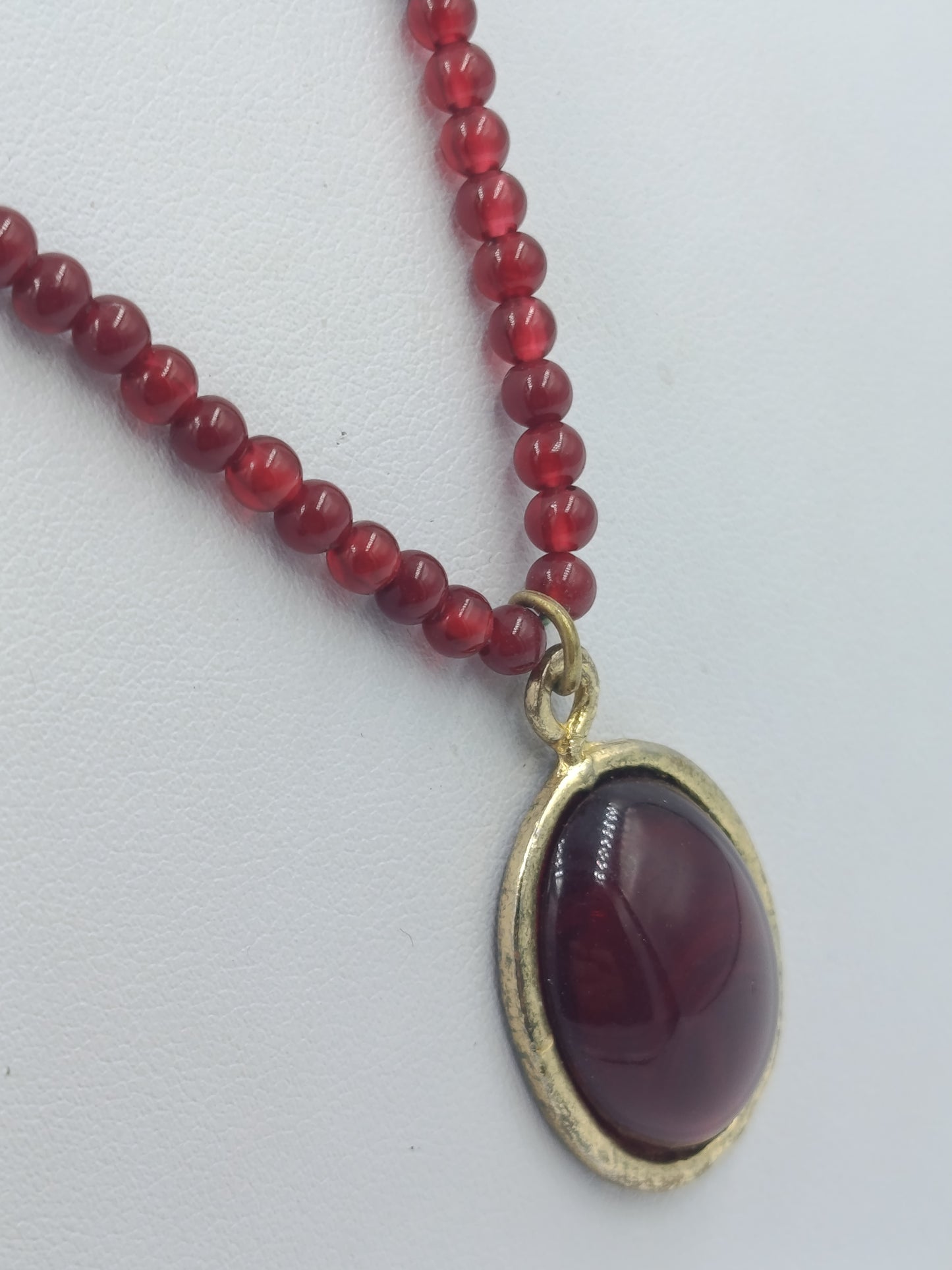 Vintage Halskette mit roten Perlen und ovalem Anhänger in goldfarbener Fassung