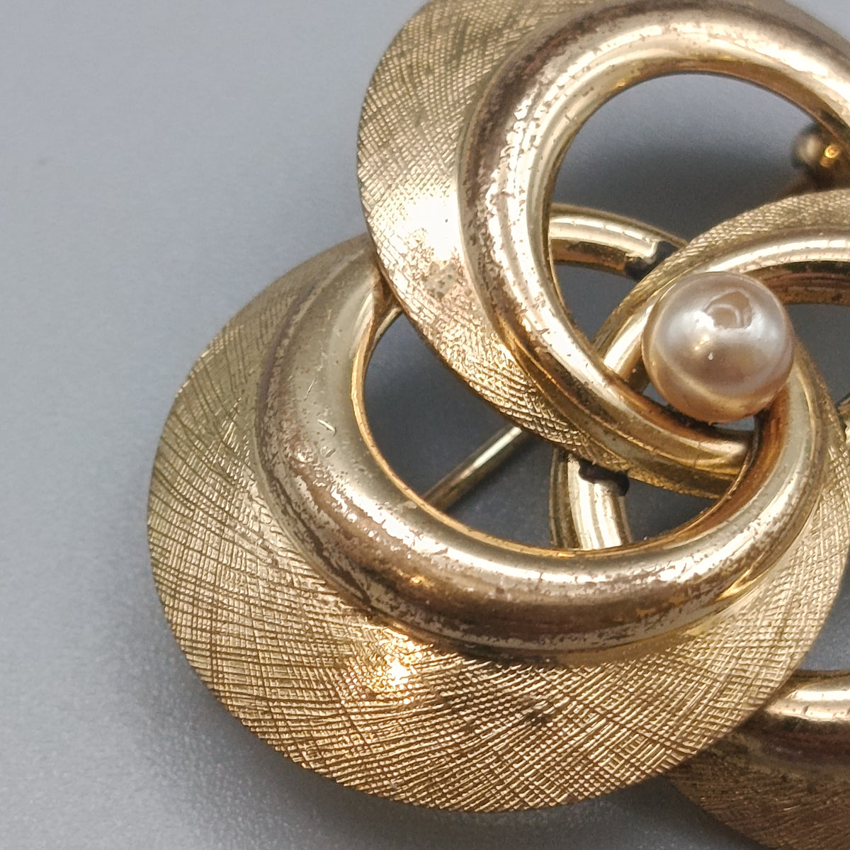 Brosche in Goldoptik – Dreifach-Schlinge mit Perle