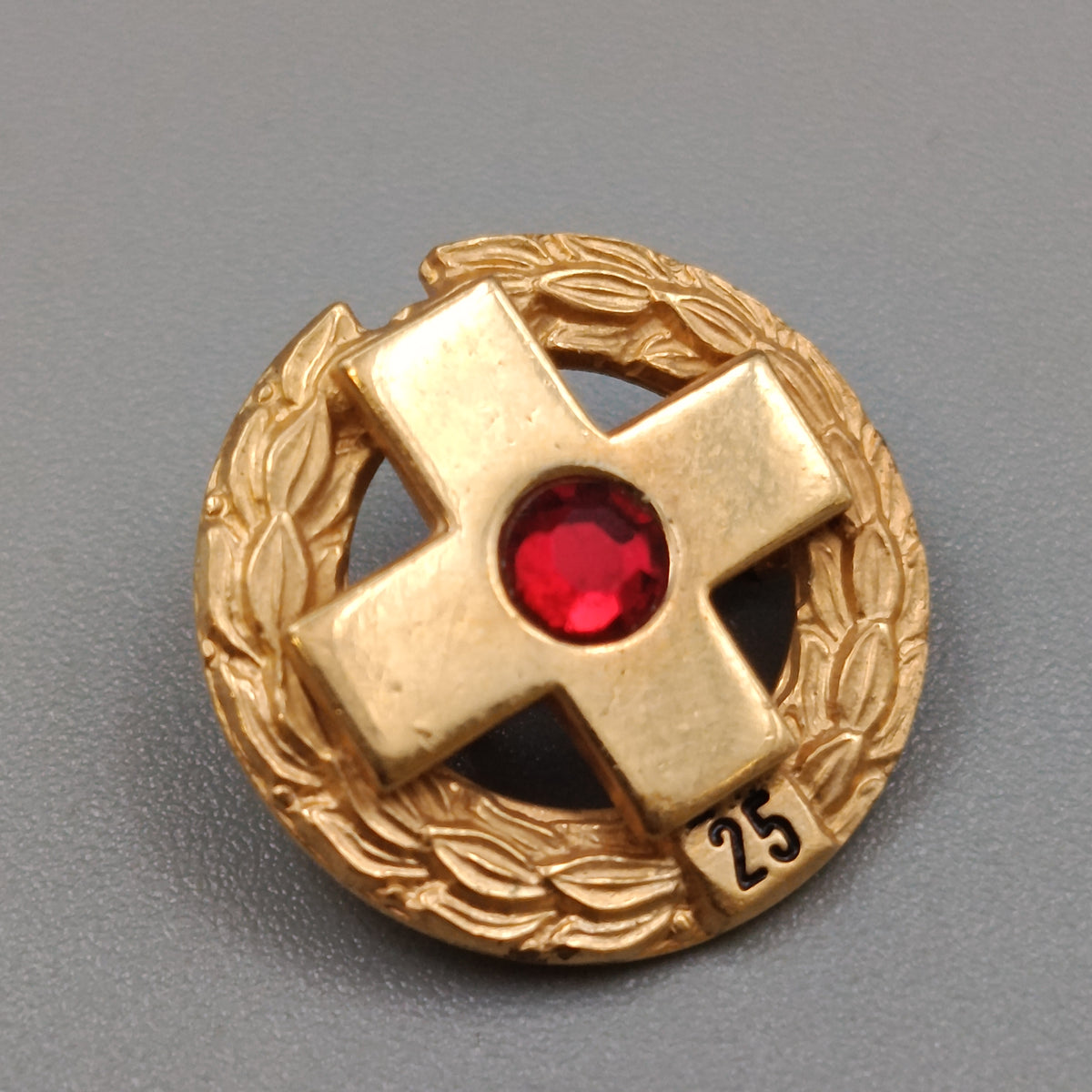 Elegante Jubiläumsbrosche mit Kreuz und rotem Stein