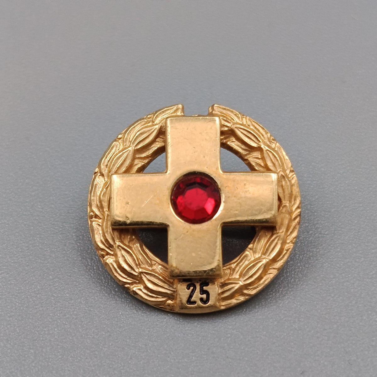 Elegante Jubiläumsbrosche mit Kreuz und rotem Stein
