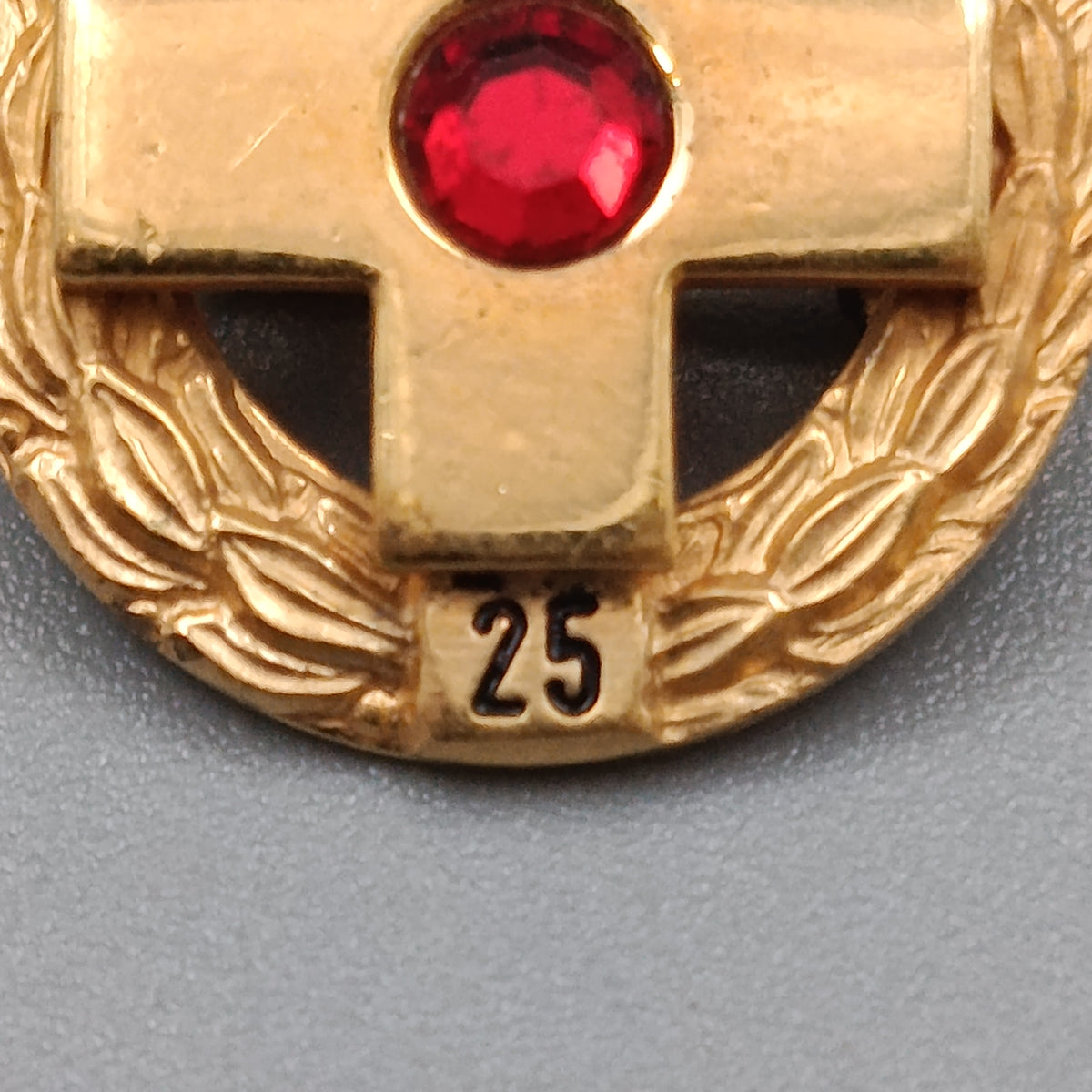 Elegante Jubiläumsbrosche mit Kreuz und rotem Stein