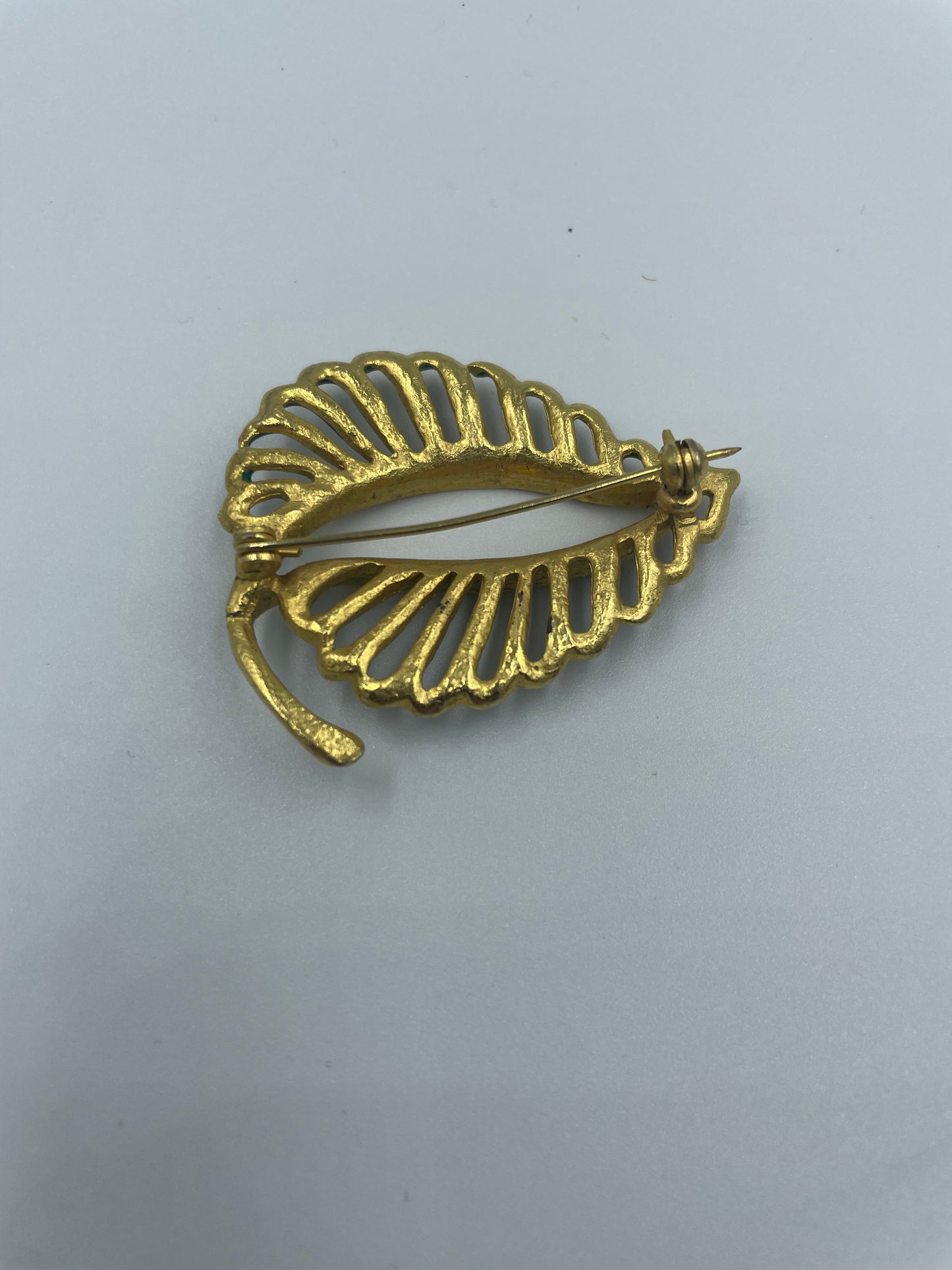 Vergoldete Brosche mit funkelnden kleinen Steinen