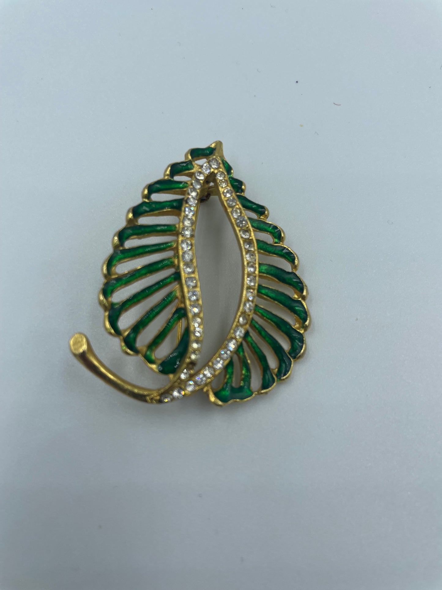 Vergoldete Brosche mit funkelnden kleinen Steinen