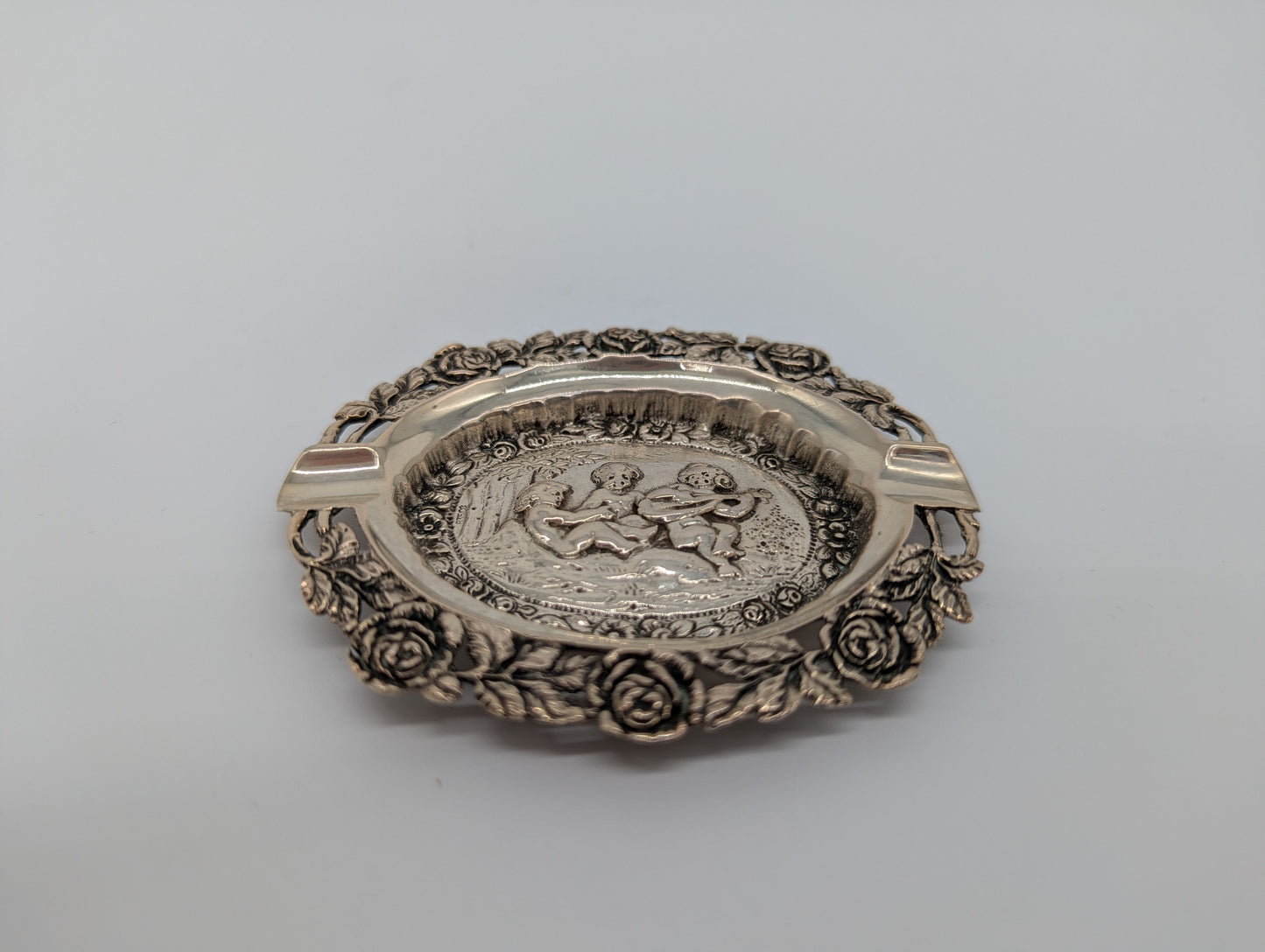 Versilberter Aschenbecher mit Puttenmotiven und reichem Dekor