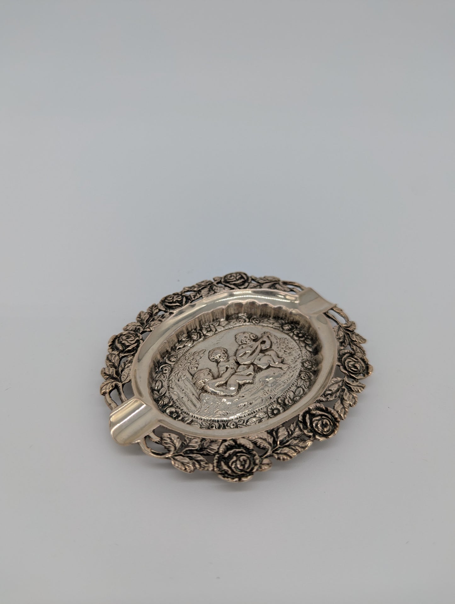 Versilberter Aschenbecher mit Puttenmotiven und reichem Dekor